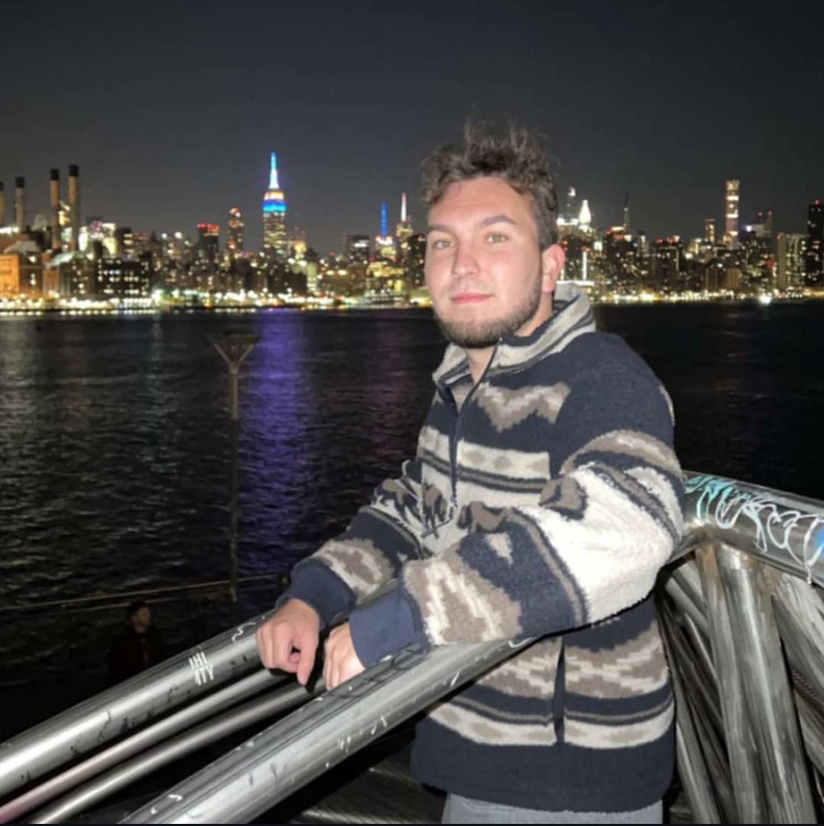 Will hanging out on a metal structure, with New York City in the background